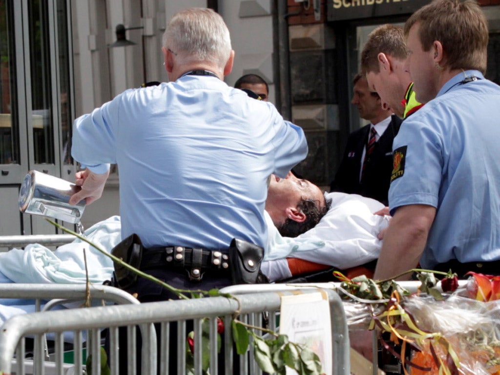 Medics take away the man who set himself on fire outside the Breivik trial in Oslo
